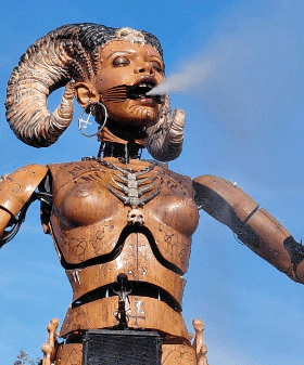 Escultura de una figura con cuernos bajo un cielo azul